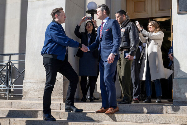 Elon Musk, the leader of the Department of Government Efficiency, shakes hands with U.S. Secretary of Defense Pete Hegseth.
